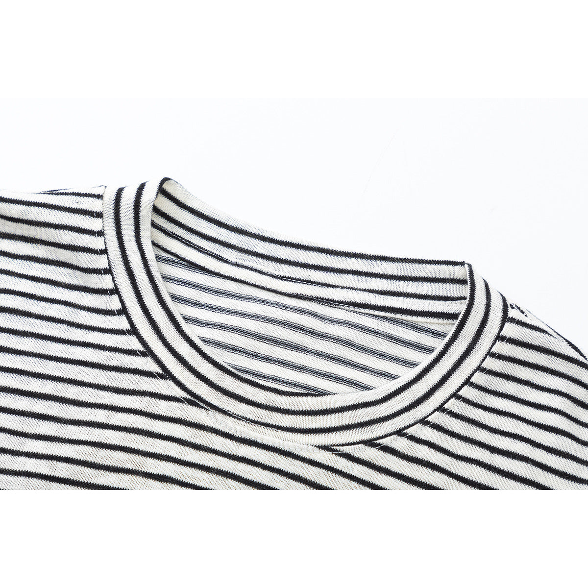 Close-up of a black-and-white striped shirt showing its crew neckline and ribbed collar.