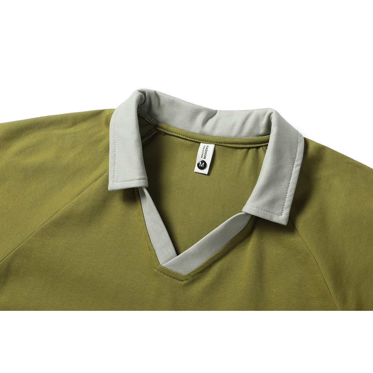Close-up of an olive-green shirt with a light gray pointed collar and matching V-neck trim; size M label visible.