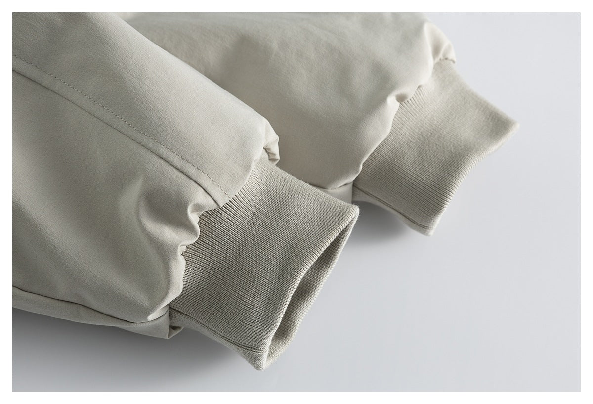 Close-up of the light beige jacket’s gathered sleeve ends and rib-knit cuffs.