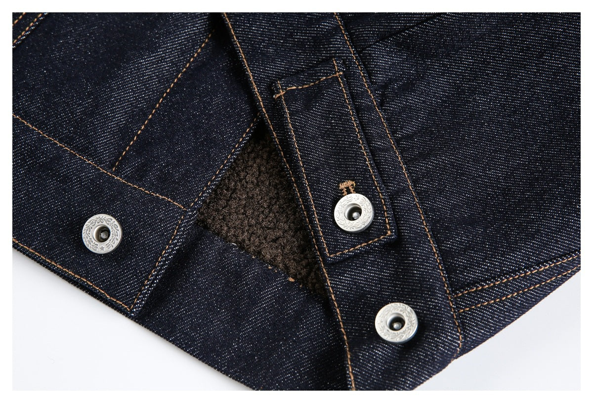 Close-up of a dark indigo denim jacket opening with silver snaps, tan stitching, and brown textured lining.