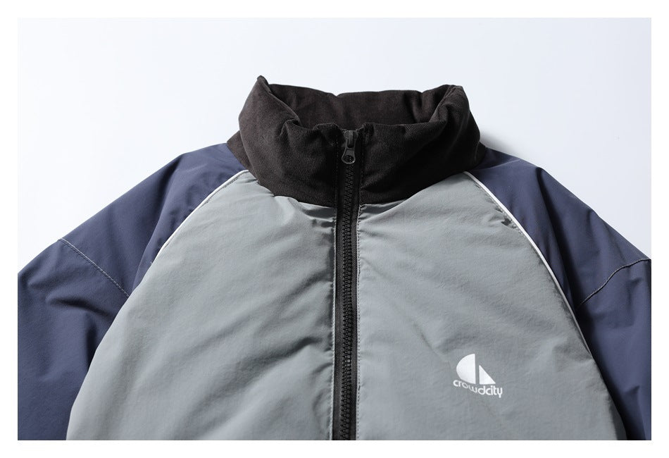 Upper front detail of the gray and navy jacket, showing its black stand collar, zipper, and white chest logo.