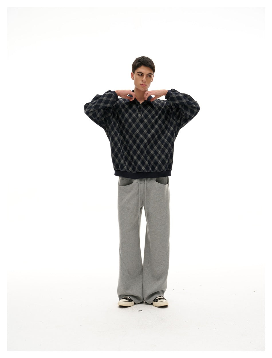 Full-length model wearing a navy and gray diamond-plaid pullover with gray wide-leg pants.