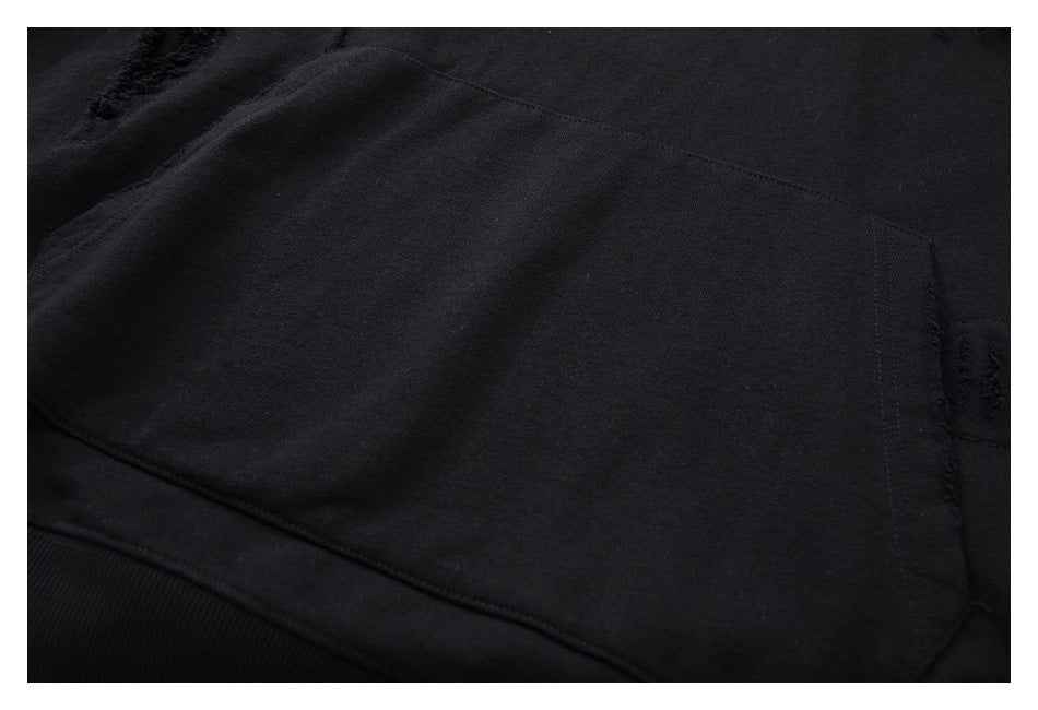 Close-up of the large front pocket and lower seam on a black hoodie.