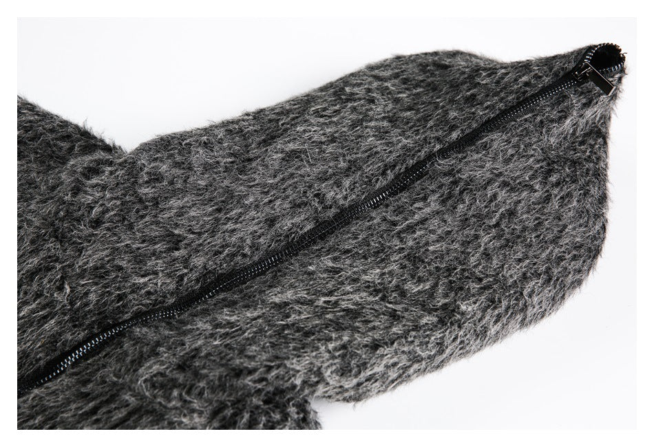 Close-up of a long black zipper running diagonally across shaggy charcoal-gray fabric.