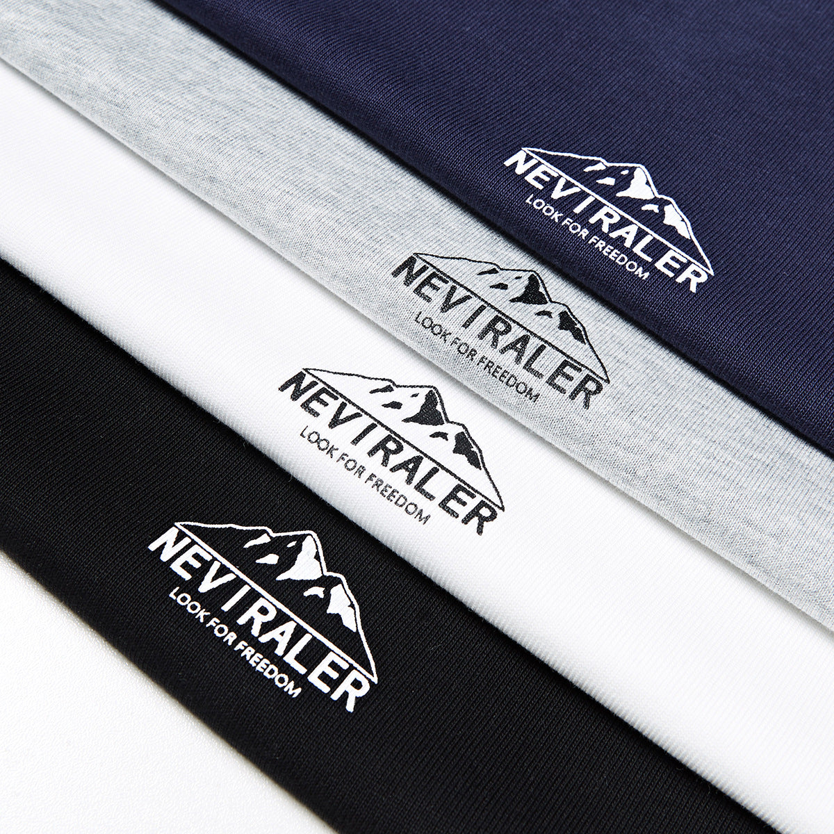 Close-up of mountain logo prints on navy, heather gray, white, and black T-shirt fabric.