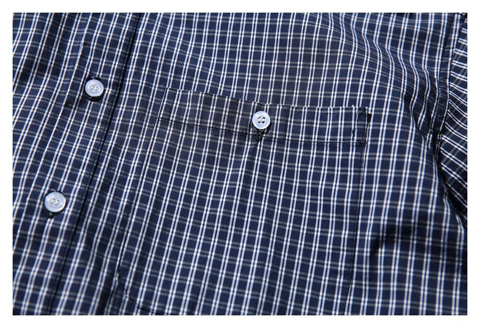 Close-up of the navy-and-white plaid shirt's buttoned chest pocket and front placket.