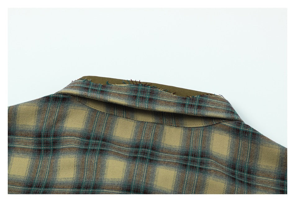 Close-up of the folded collar on a tan, teal, and brown plaid shirt.