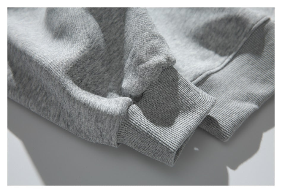 Close-up of the gray sweatshirt’s sleeve ending in a ribbed cuff, with part of the ribbed hem visible.
