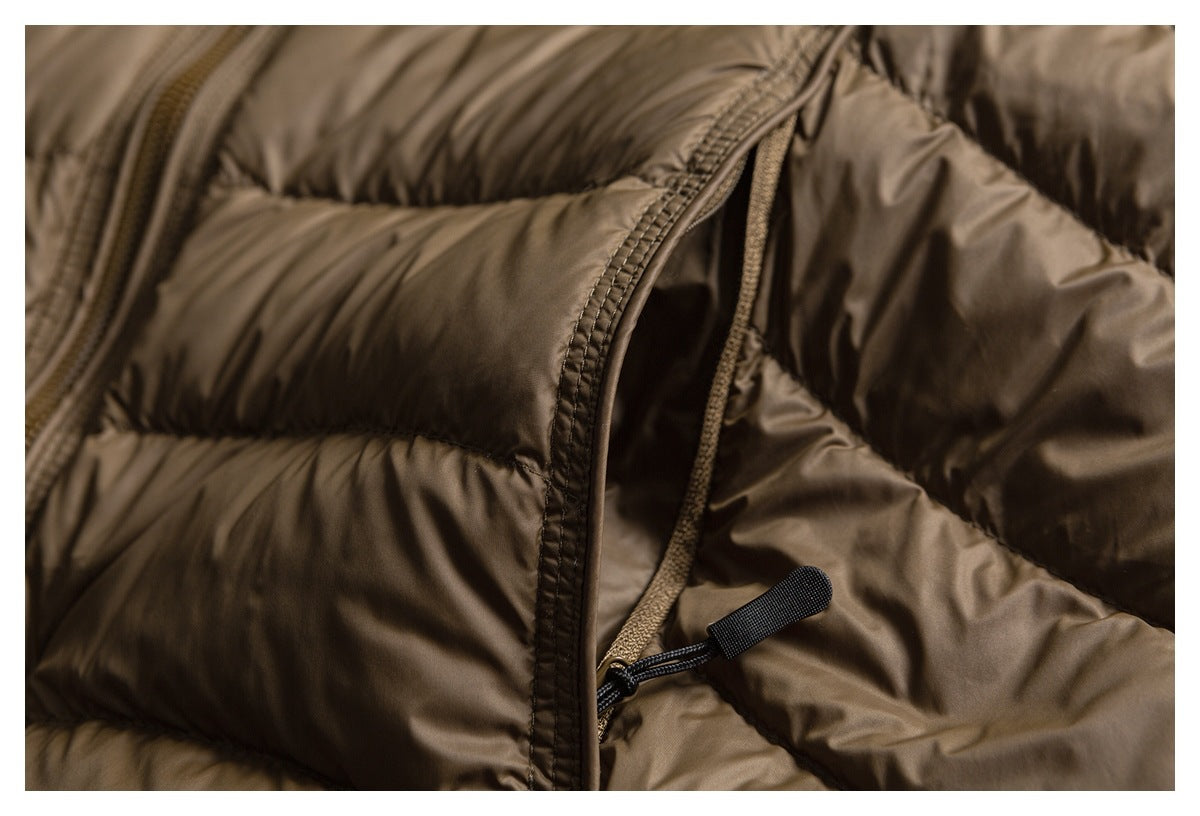 Close-up of a slanted pocket opening and pull on the brown quilted jacket.