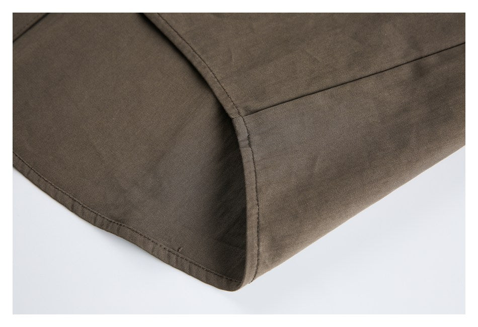 Close-up of curved stitched seams and a finished edge on brown garment fabric.