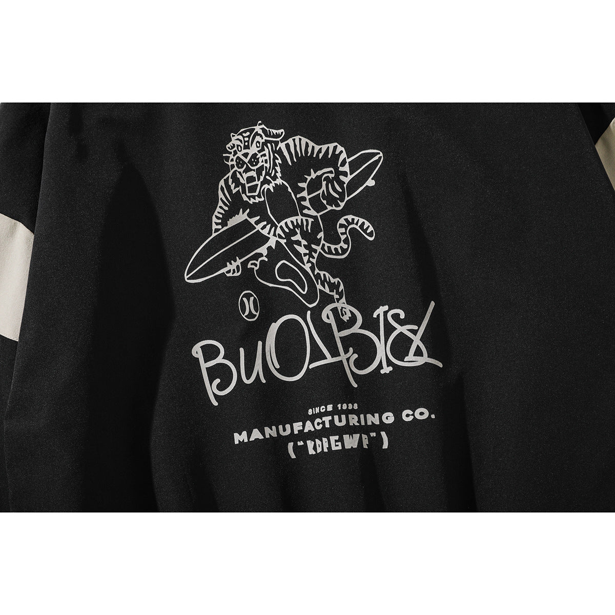 Close-up of the jacket's large cream back graphic showing a tiger and stylized lettering.