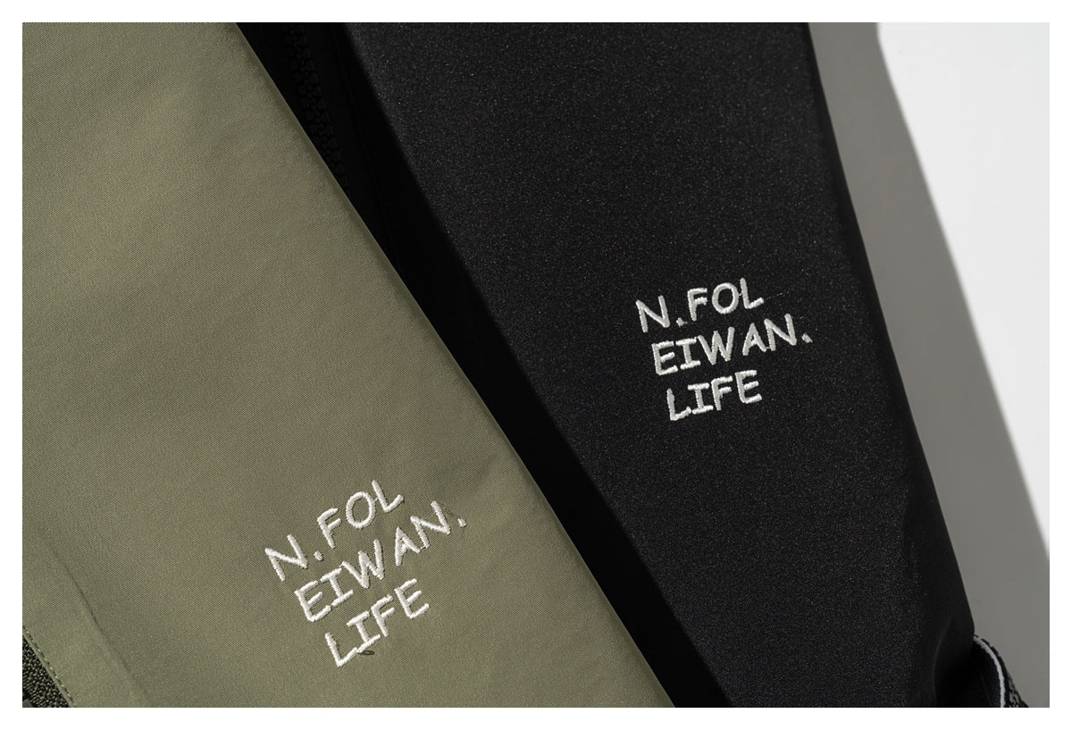 White embroidered lettering on olive-green and black garment panels.