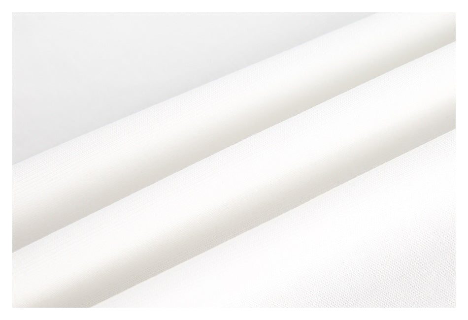 Close-up of white fabric folded into diagonal layers, showing its fine surface texture.