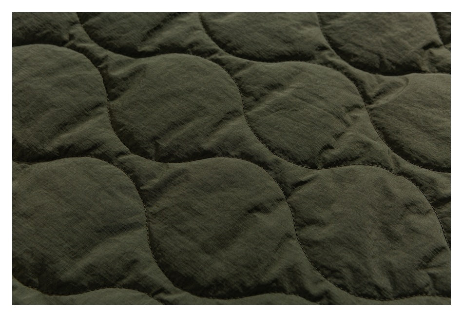 Close-up of the olive-green jacket's rounded quilted stitching.