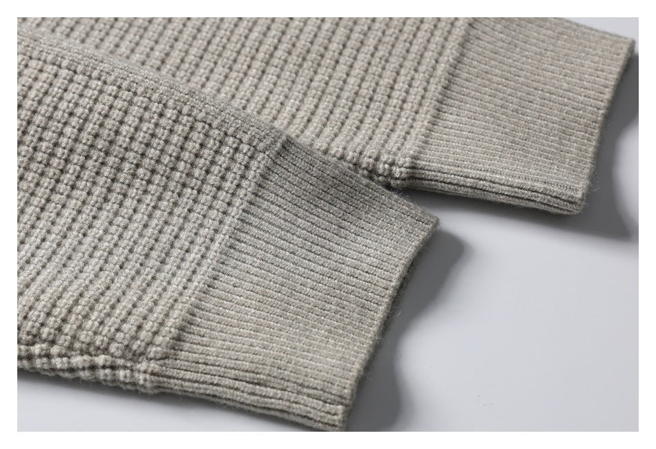 Close-up of the light gray knit garment's sleeves and wide ribbed cuffs.