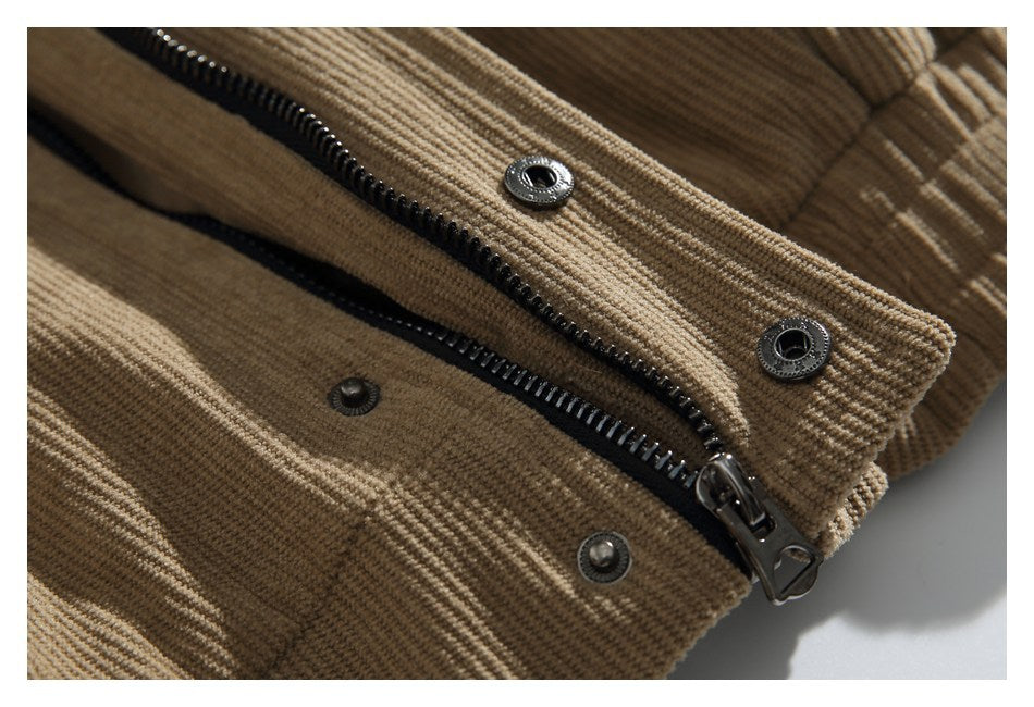 Close-up of a tan jacket’s black zipper and metal snap fasteners.