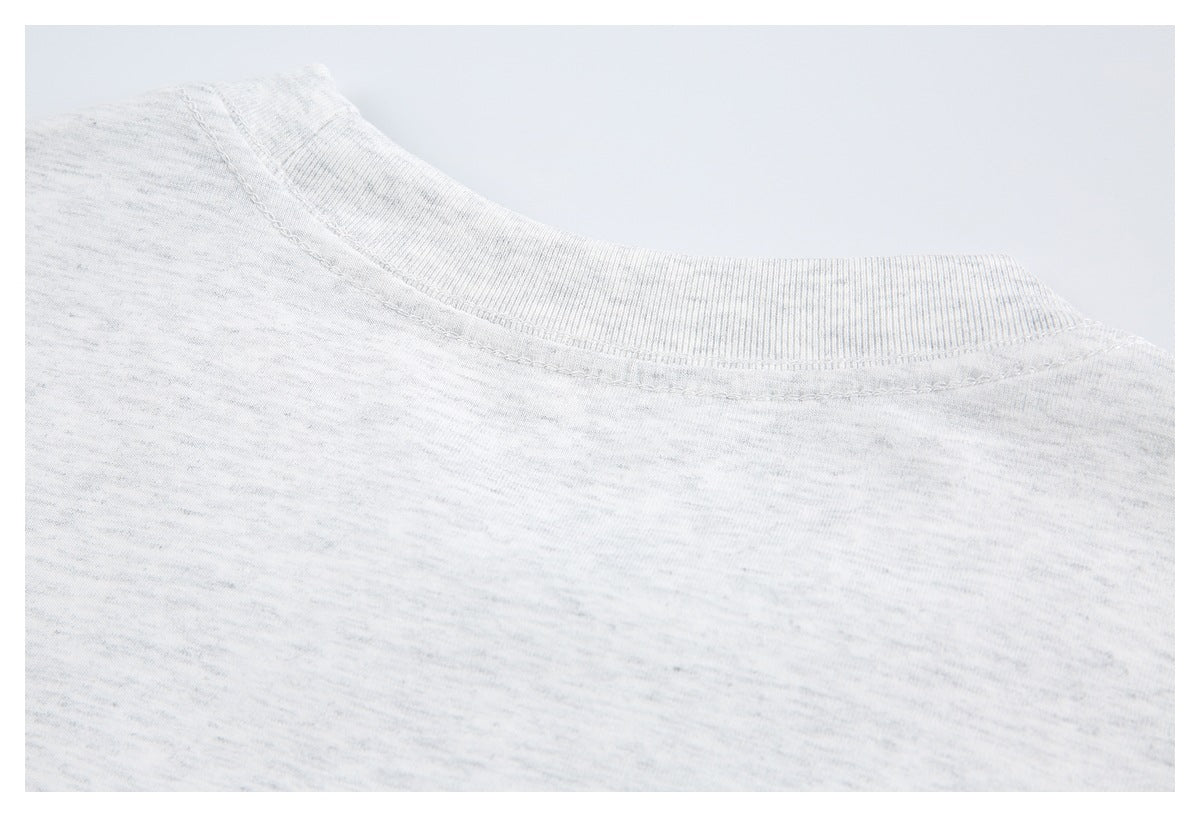 Close-up of the ribbed crew neckline and shoulder seam on a white heathered knit top.