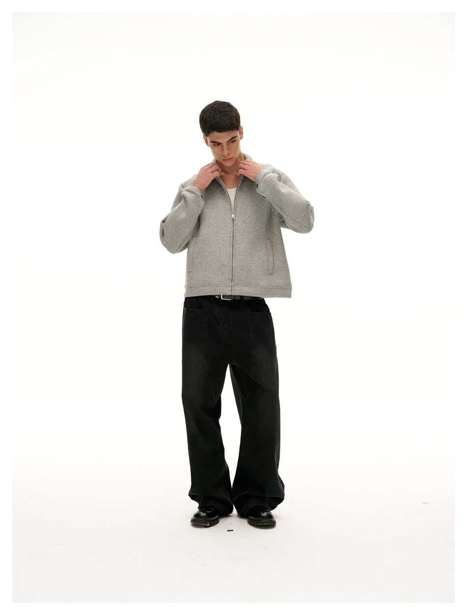 Model wearing a light gray zip-front jacket with a raised collar and black wide-leg pants, shown full length.