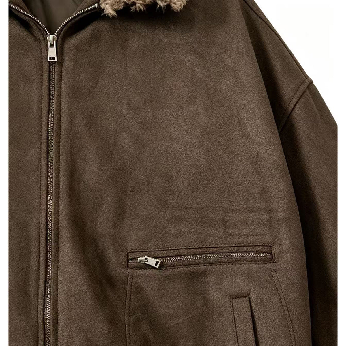 Close-up of the brown jacket's front zipper, silver zip pocket, and lower patch pocket.
