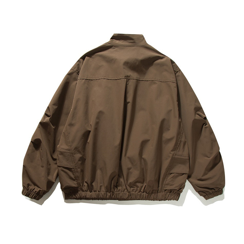 Brown jacket flat back view showing yoke seam, center pleat, side pocket details and elastic cuffs and hem
