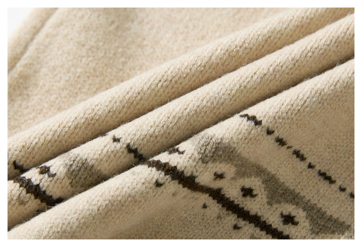 Close-up of cream knit fabric with dark brown geometric patterning along folded edges.