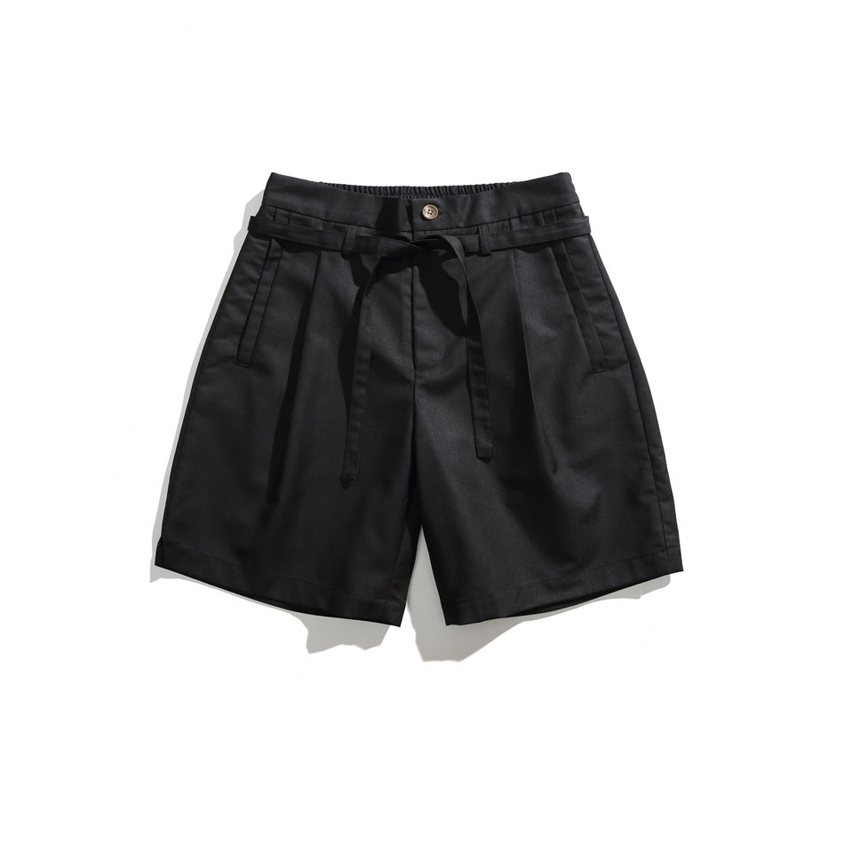 Black pleated knee-length shorts with button, tie belt and slanted front pockets, flat lay