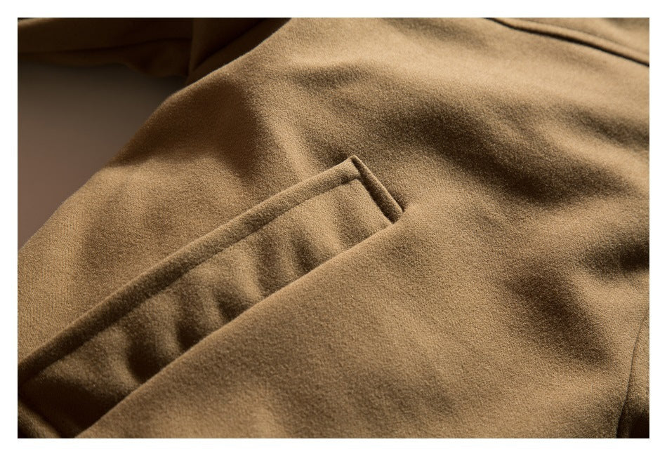 Close-up of a diagonal welt pocket on a camel-brown coat.