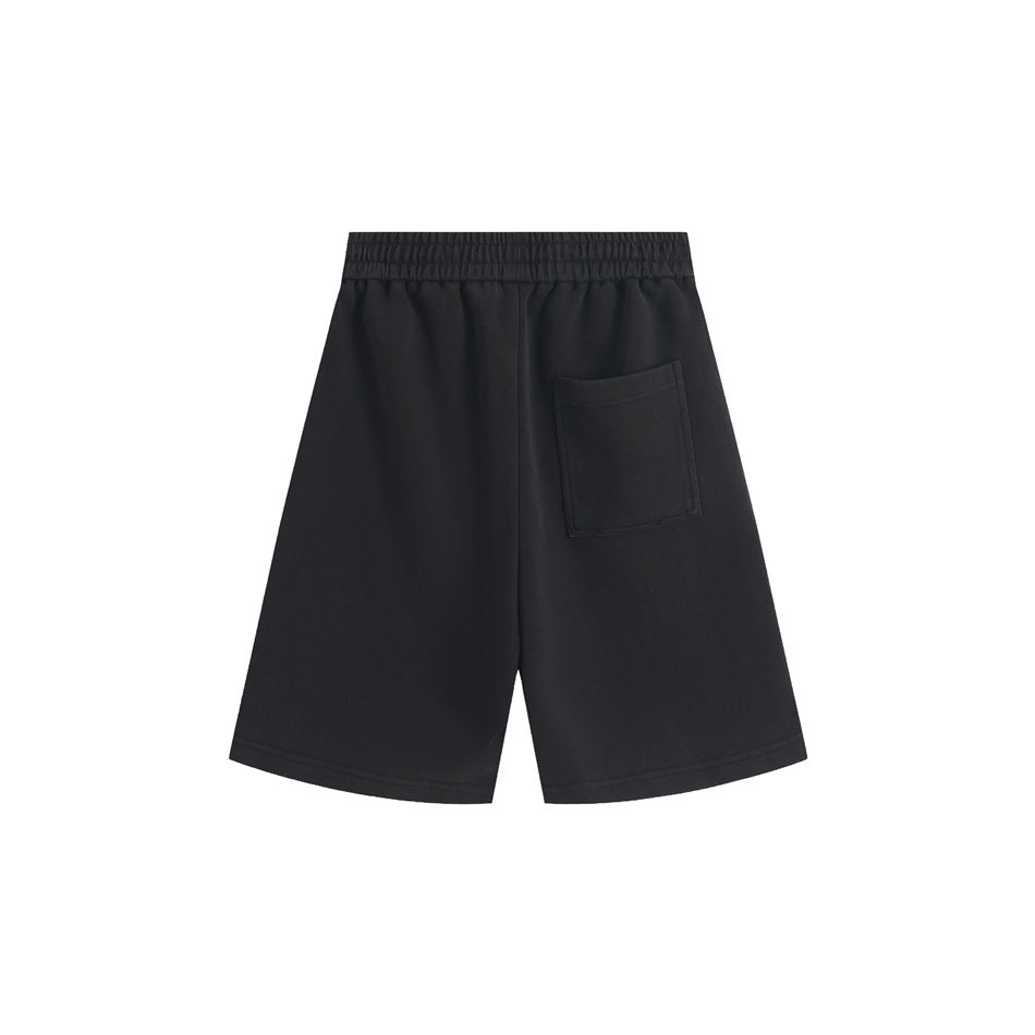 Back view of black shorts with an elastic waistband, a single patch pocket, and wide legs.