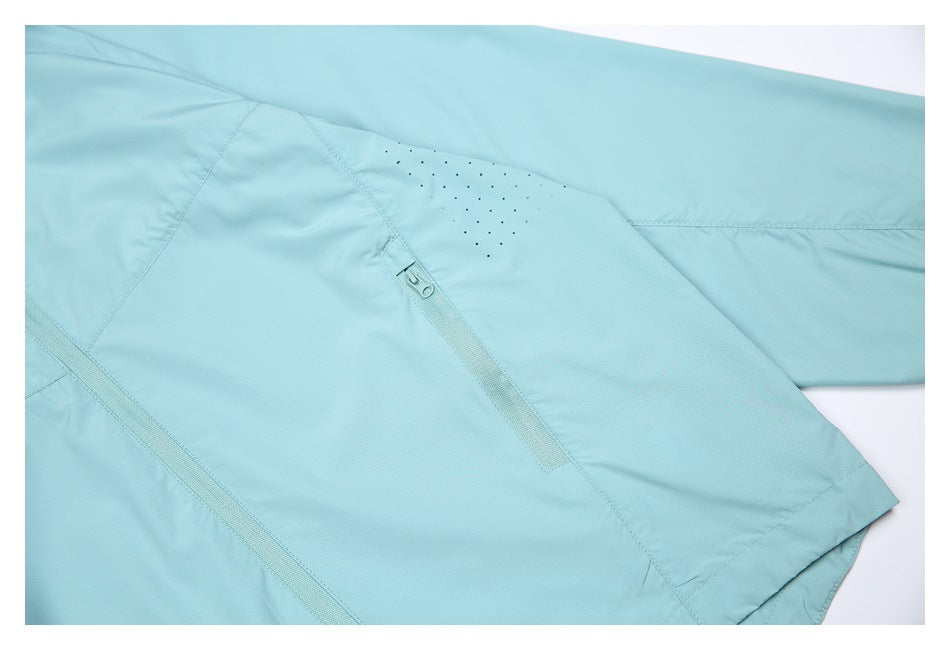 Close-up of a light aqua jacket showing a sleeve, perforated ventilation holes, and a zip pocket.