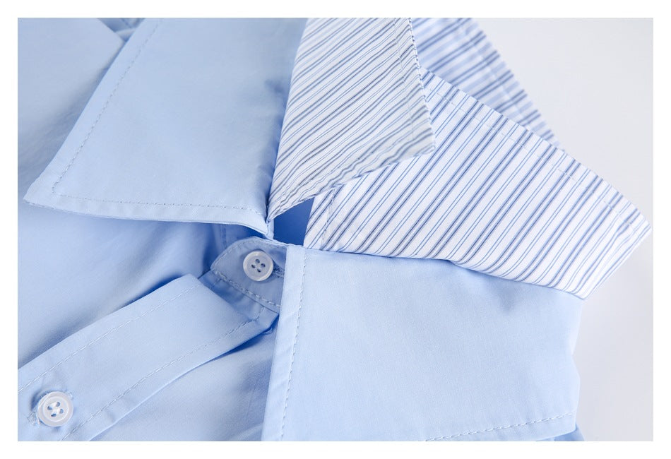 Close-up of a light blue shirt collar with blue-and-white stripes and white buttons.