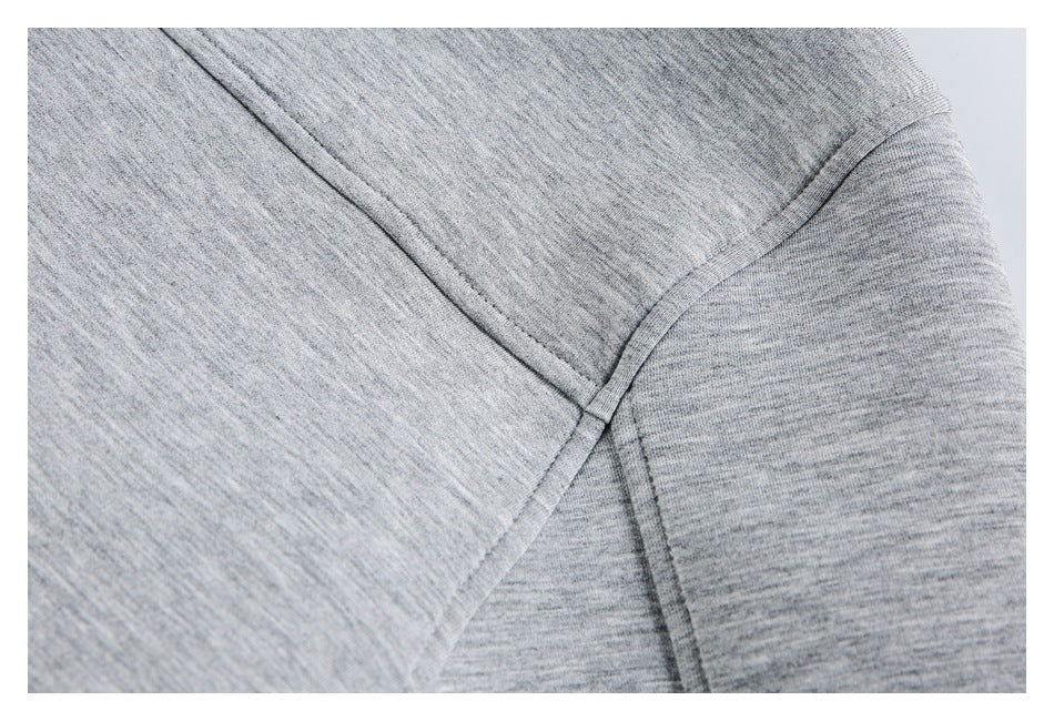 Close-up of heather gray knit garment with curved seam lines meeting at a junction.