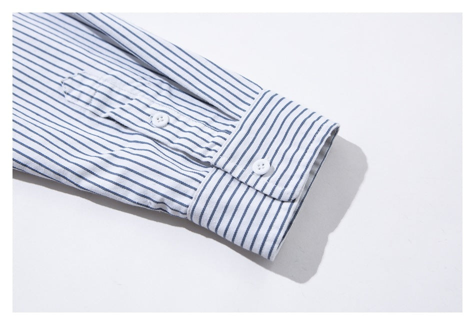 Close-up of a white shirt sleeve with thin blue stripes, showing the buttoned cuff and sleeve placket.