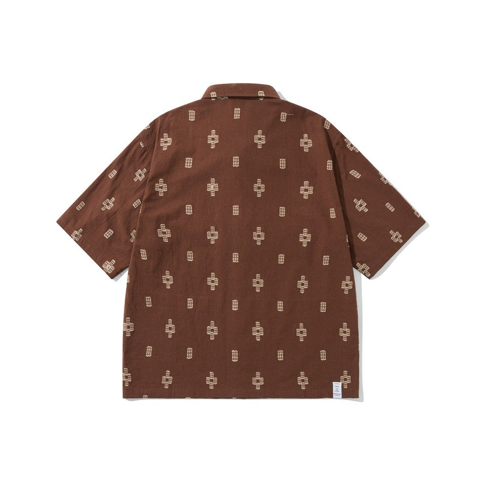 Back view of brown short-sleeve shirt with all-over cream cross and rectangle motif and small hem label