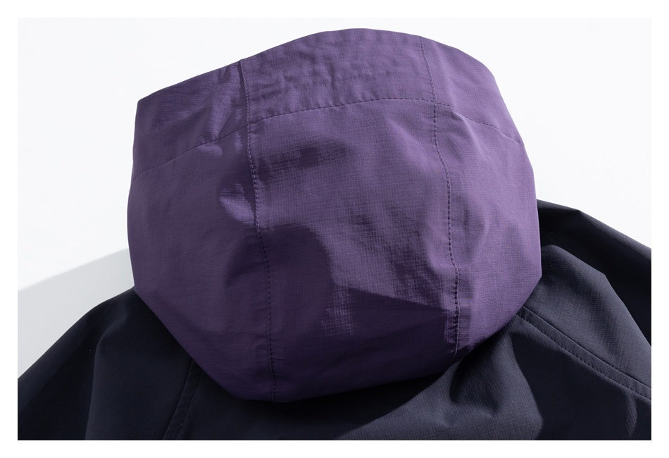 Rear close-up of a purple hood attached to a dark navy jacket.