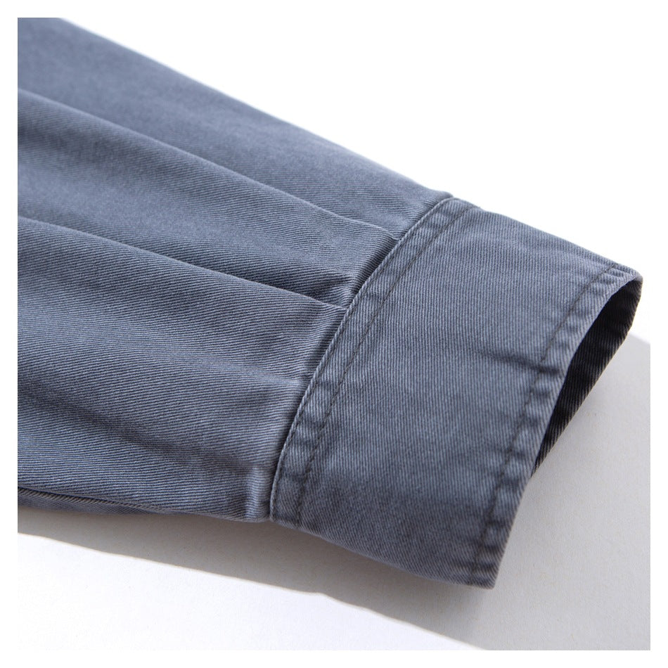 Close-up of a slate blue-gray jacket sleeve ending in a wide stitched cuff.