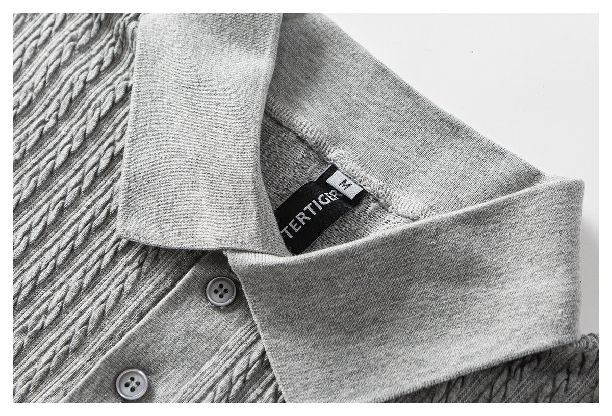 Close-up of a gray cable-textured polo shirt collar, two buttons, and an inside label.