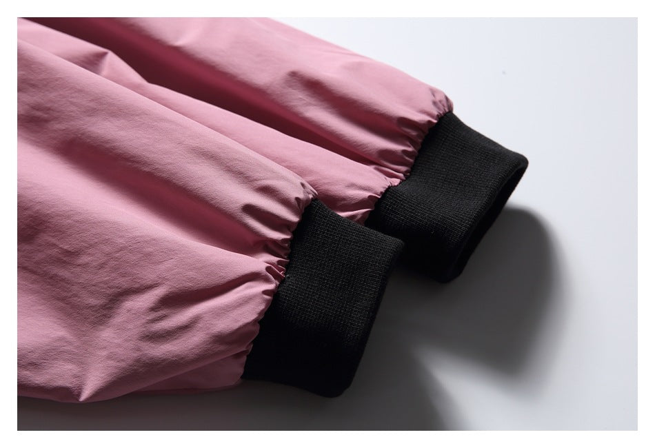 Close-up of pink jacket sleeves finished with black ribbed cuffs.