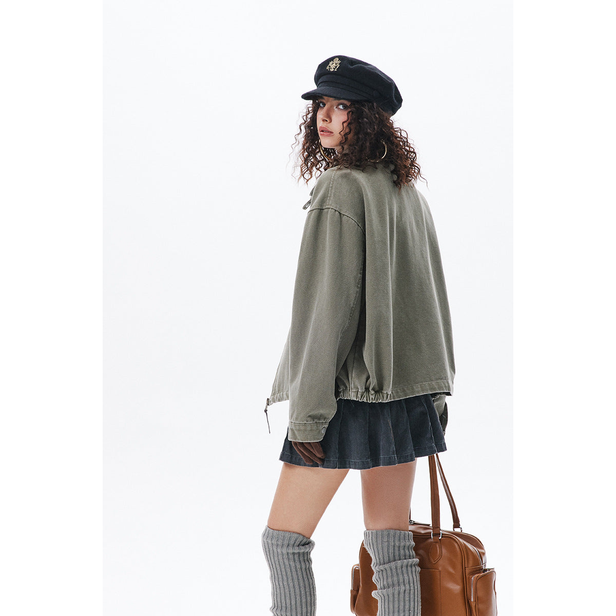 Rear view of a model wearing an oversized olive-gray jacket with an elasticized hem.