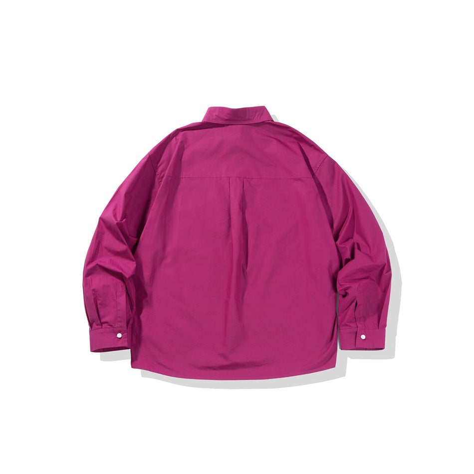 Back view of a magenta long-sleeve button-up shirt with a center pleat and button cuffs on white.