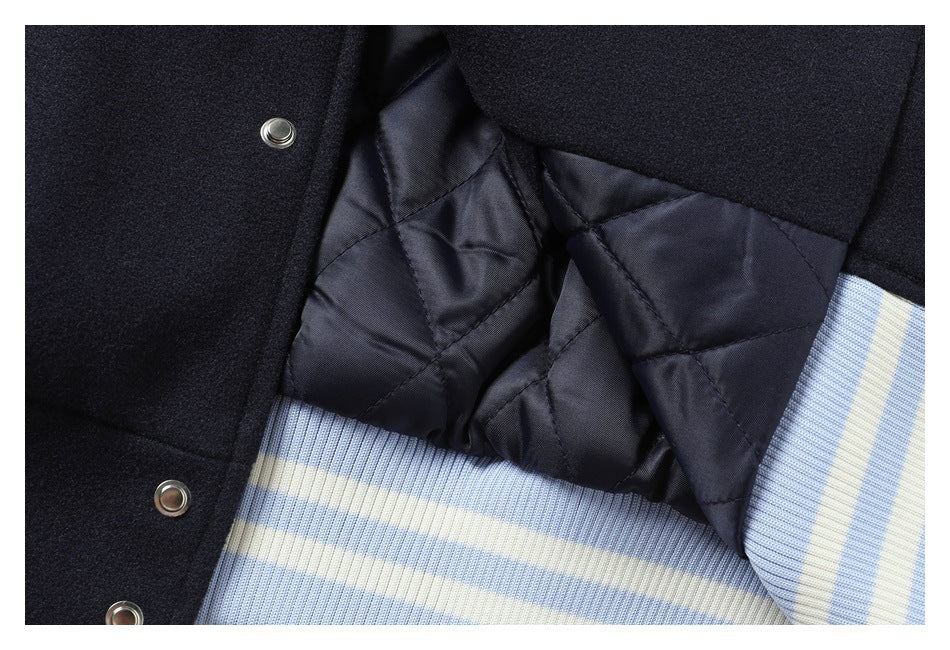 Close-up showing the navy garment's quilted lining, snap closures, and pale blue and cream striped ribbing.