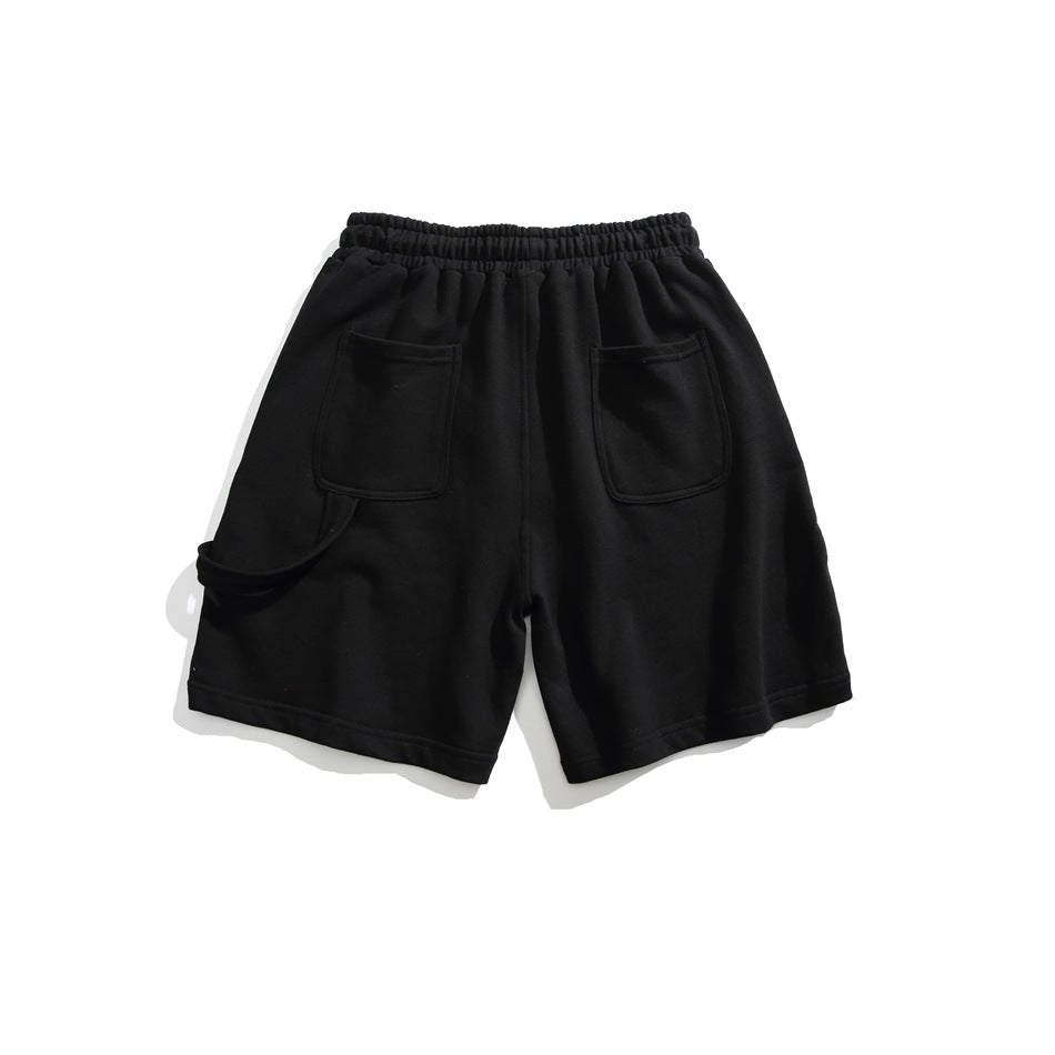 Front view of black shorts with an elastic waistband and two large front patch pockets, laid flat on white.