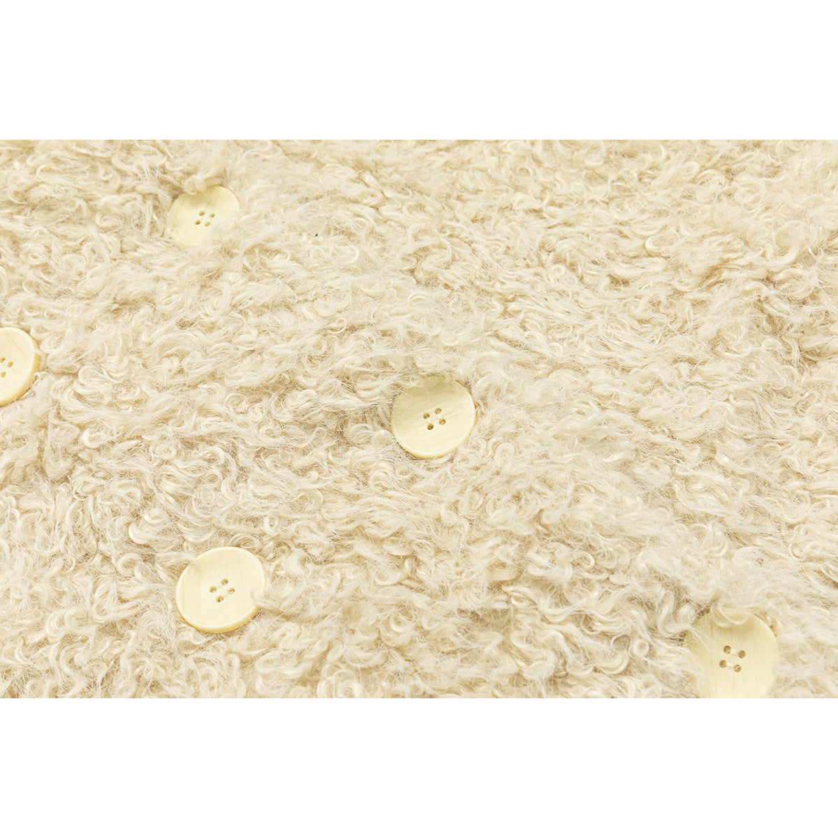 Close-up showing the cream jacket’s curly surface texture and pale buttons.