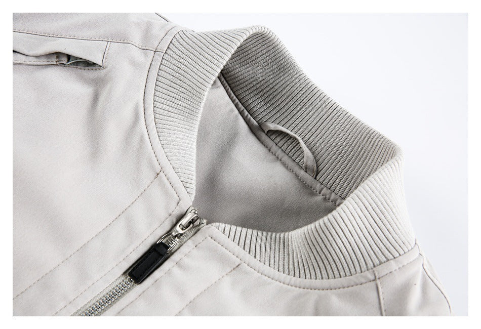 Close-up of a light gray jacket's ribbed collar, inner hanging loop, and front zipper.