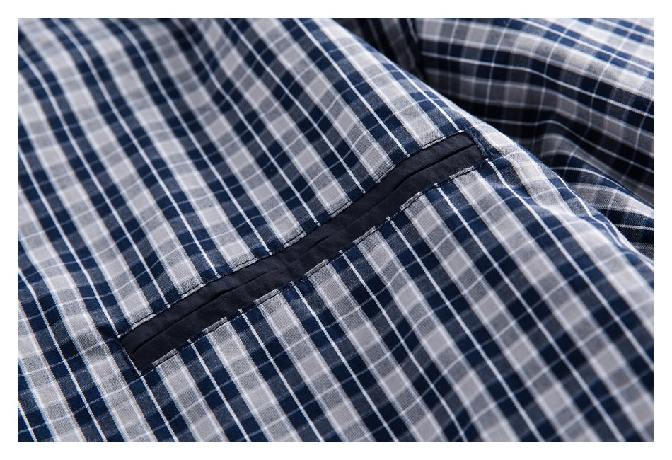 Close-up of a dark navy panel seam across blue, gray, and white plaid fabric.