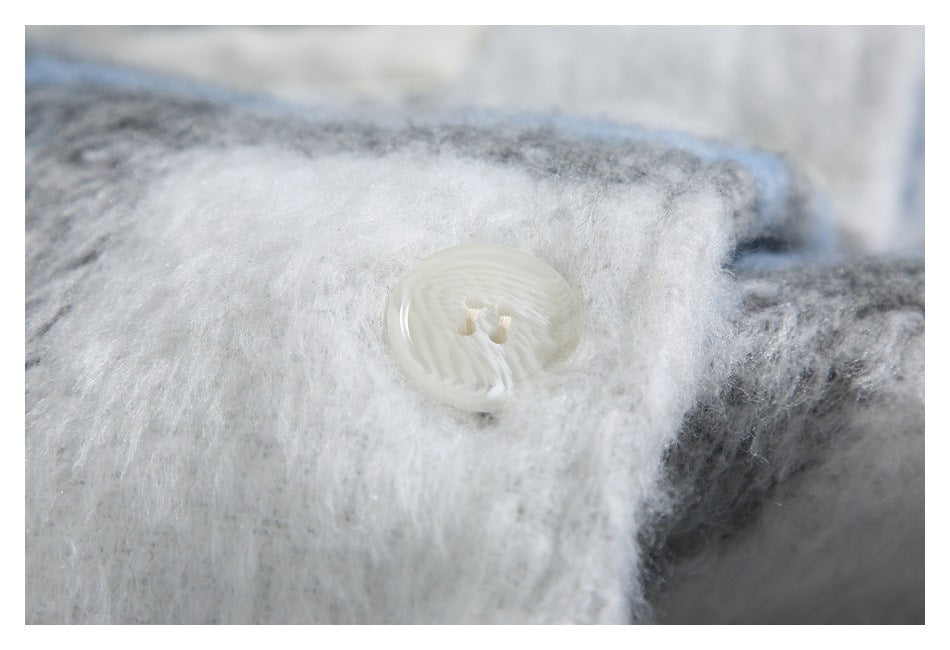White four-hole button on a fuzzy white panel bordered by blue and gray plaid fabric.