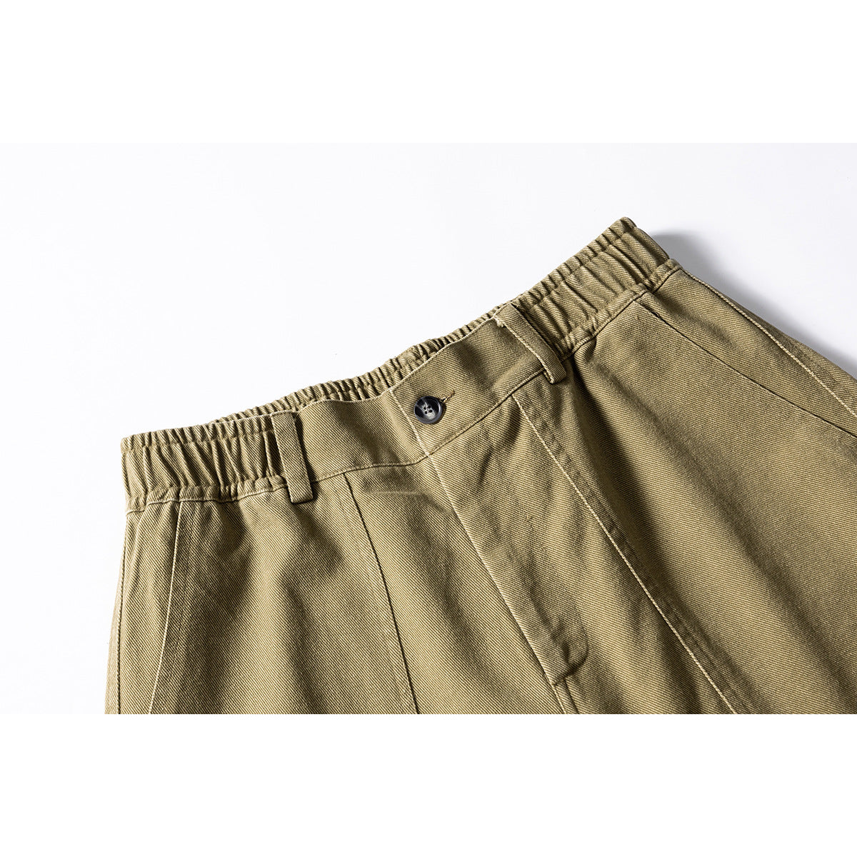 Close-up of olive-khaki shorts showing an elastic waistband, button, belt loops, and front seams.