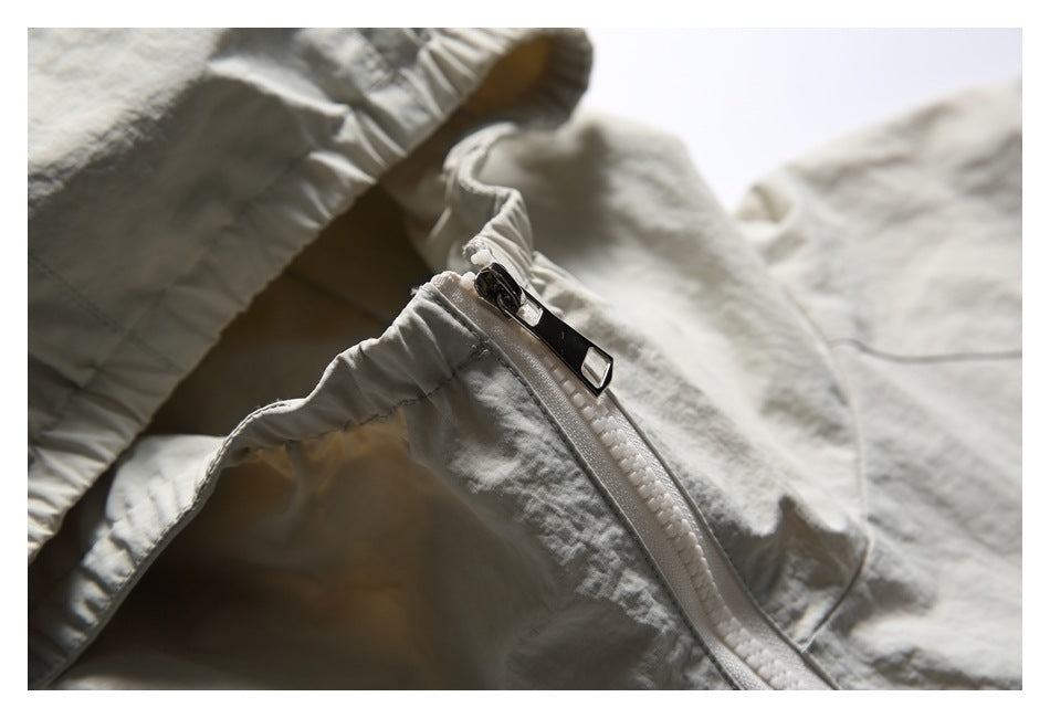 Close-up of the off-white hooded jacket's white zipper and metal pull.