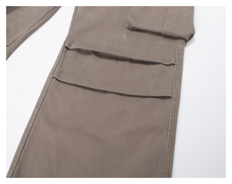 Close-up of taupe trouser legs showing layered pleated detailing.