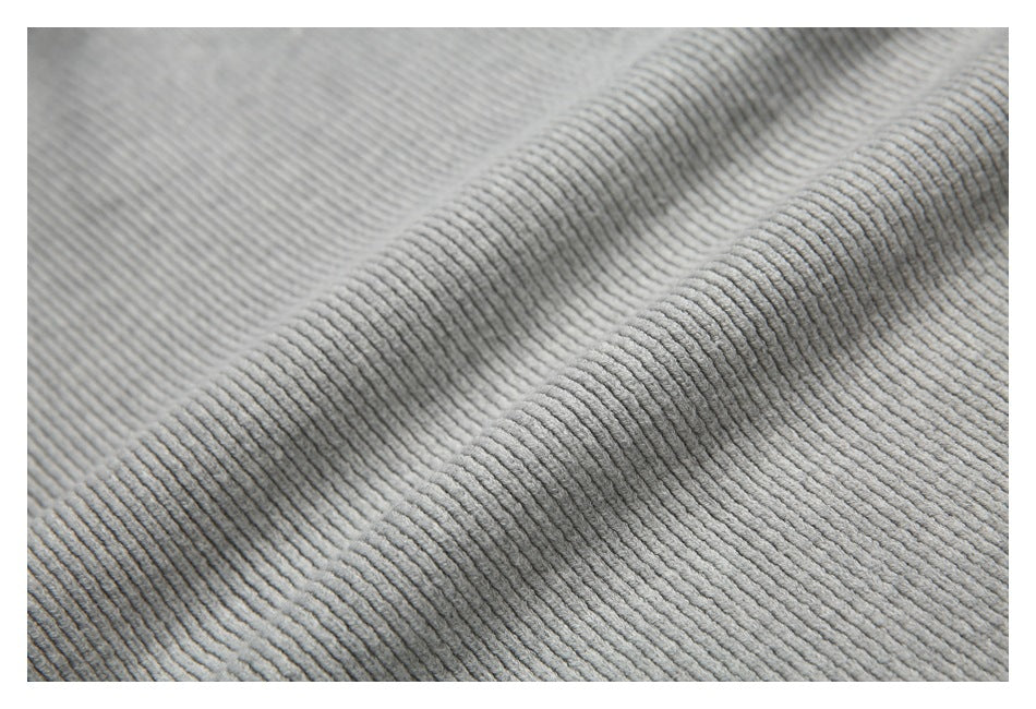 Close-up of pale gray ribbed fabric with raised diagonal folds.