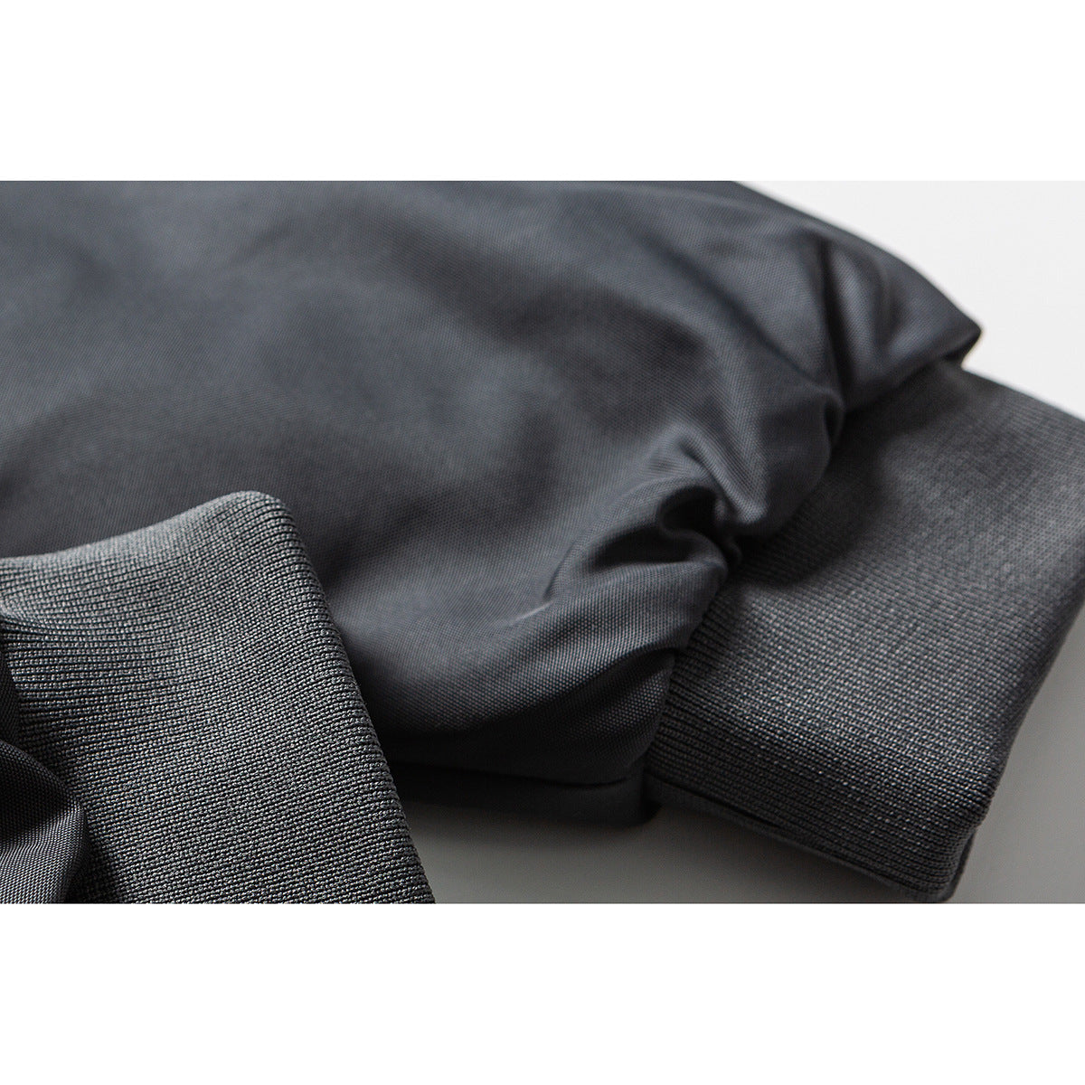 Close-up of dark jacket fabric and ribbed cuff.